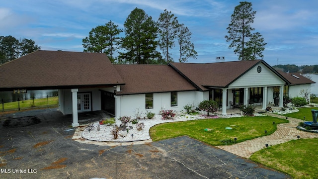 view of front of property with driveway, a patio, fence, french doors, and a front yard