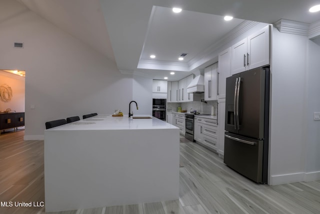 kitchen with custom range hood, a sink, stainless steel appliances, light countertops, and backsplash