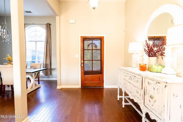 entryway with a notable chandelier and dark hardwood / wood-style flooring