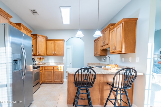 kitchen featuring sink, kitchen peninsula, a kitchen breakfast bar, stainless steel appliances, and pendant lighting