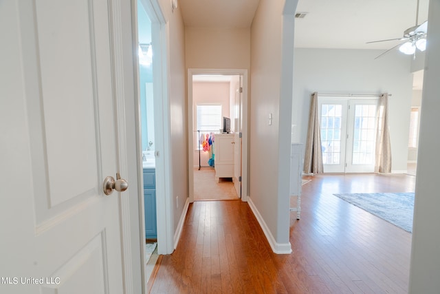 hall with light hardwood / wood-style flooring and a wealth of natural light