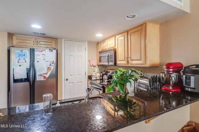 2046 Beach Blvd Unit 321, Biloxi, MS 39531 - kitchen featuring visible vents, appliances with stainless steel finishes, dark stone counters, and light brown cabinetry