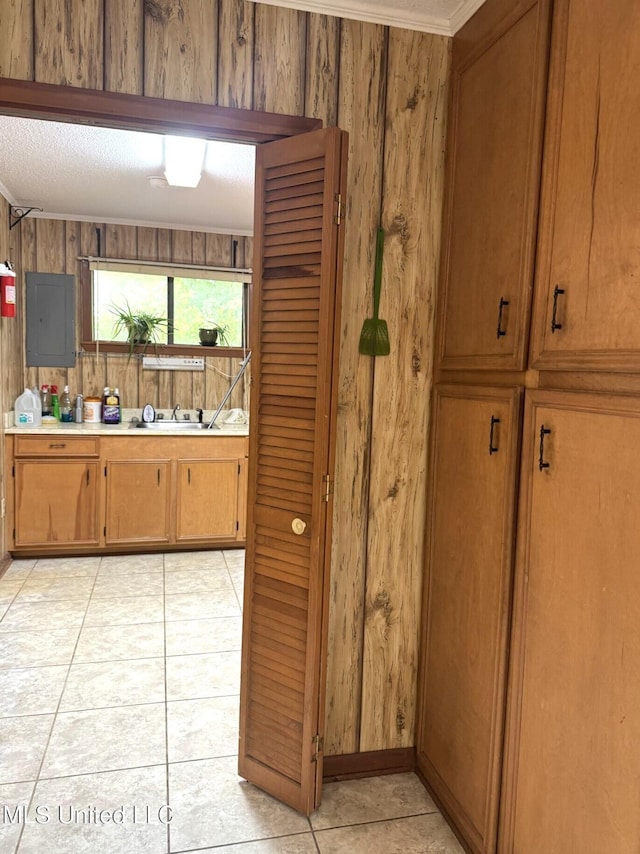 25 Cloverdale Rd, Natchez, MS 39120 - kitchen with electric panel, wood walls, light countertops, brown cabinetry, and light tile patterned floors