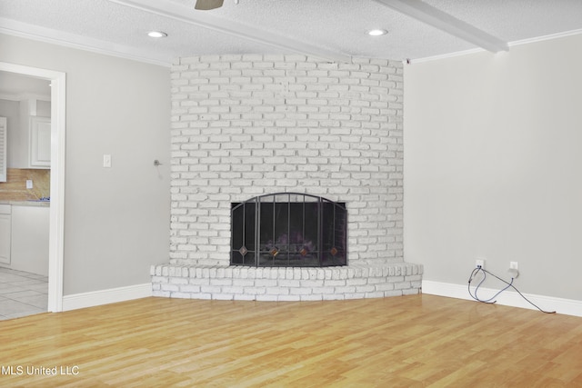 429 Linda Dr, Biloxi, MS 39531 - unfurnished living room with a textured ceiling, wood finished floors, a brick fireplace, ornamental molding, and a ceiling fan