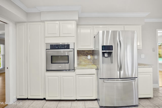 429 Linda Dr, Biloxi, MS 39531 - kitchen featuring appliances with stainless steel finishes, crown molding, light countertops, light tile patterned flooring, and white cabinetry