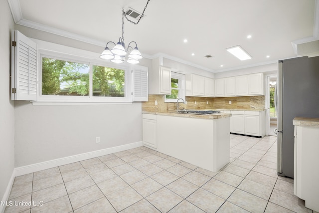 429 Linda Dr, Biloxi, MS 39531 - kitchen featuring appliances with stainless steel finishes, light countertops, backsplash, white cabinetry, and ornamental molding
