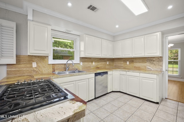 429 Linda Dr, Biloxi, MS 39531 - kitchen featuring stainless steel appliances, ornamental molding, light countertops, white cabinetry, and backsplash
