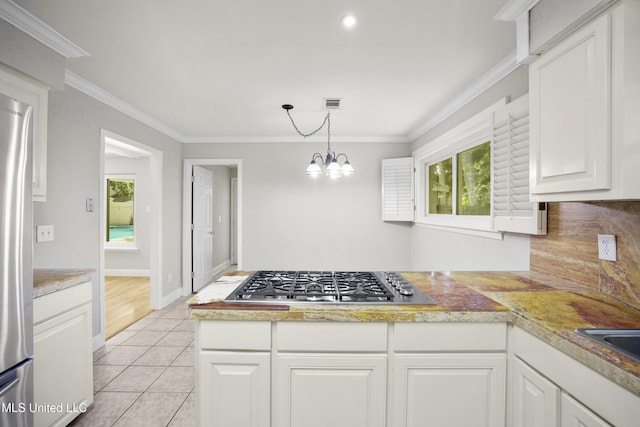 429 Linda Dr, Biloxi, MS 39531 - kitchen featuring appliances with stainless steel finishes, light countertops, white cabinets, crown molding, and a chandelier