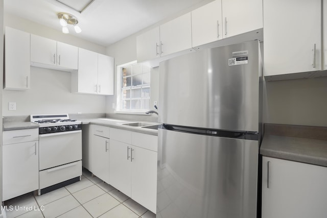 429 Linda Dr, Biloxi, MS 39531 - kitchen with freestanding refrigerator, white gas range oven, white cabinetry, light tile patterned flooring, and light countertops