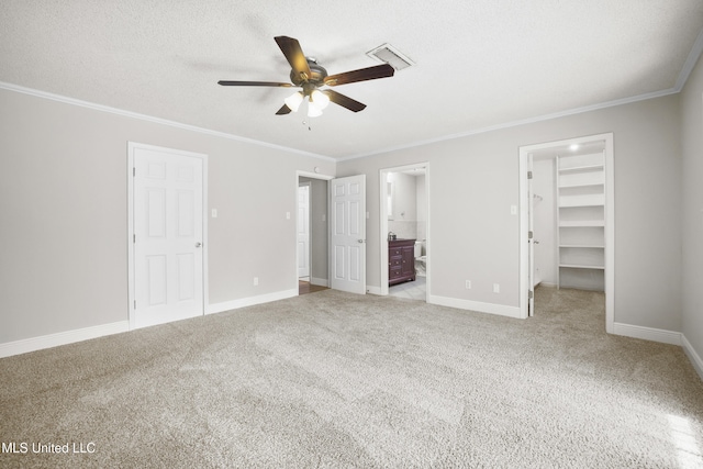 429 Linda Dr, Biloxi, MS 39531 - unfurnished bedroom with ornamental molding, carpet floors, a walk in closet, ensuite bathroom, and a ceiling fan