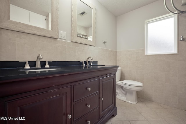 429 Linda Dr, Biloxi, MS 39531 - bathroom featuring tile walls, tile patterned flooring, vanity, and a textured ceiling