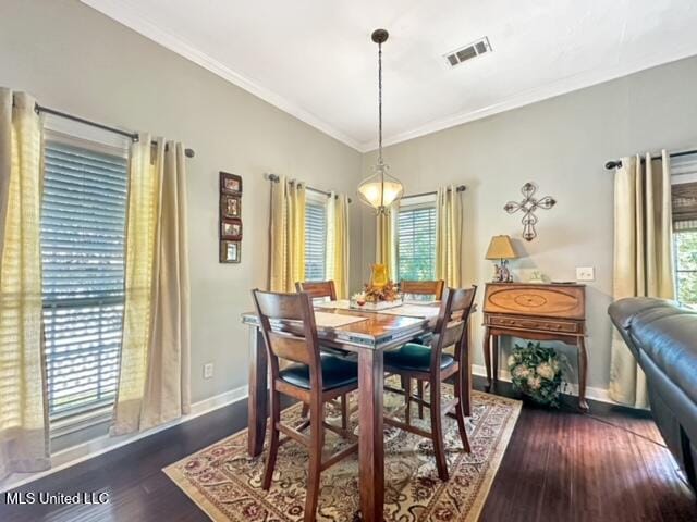 dining area with crown molding, a healthy amount of sunlight, and dark wood-type flooring