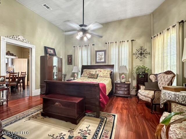 bedroom featuring ceiling fan, a towering ceiling, and dark hardwood / wood-style flooring