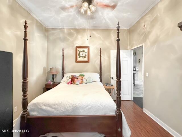 bedroom with ornamental molding, dark hardwood / wood-style floors, and ceiling fan