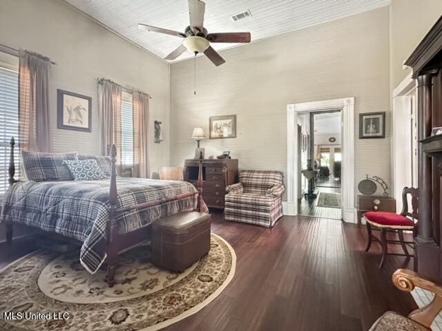 bedroom with a towering ceiling, dark wood-type flooring, and ceiling fan