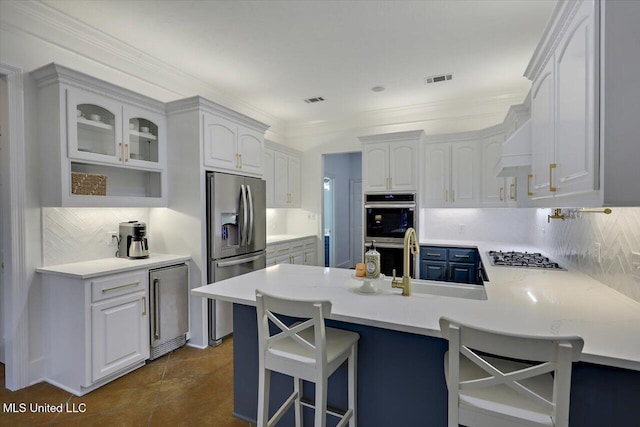 kitchen with a breakfast bar, white cabinetry, sink, kitchen peninsula, and stainless steel appliances