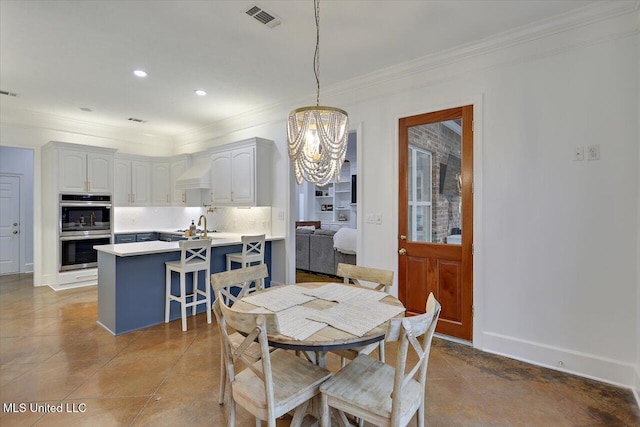 dining room with sink, a notable chandelier, crown molding, and light tile patterned floors