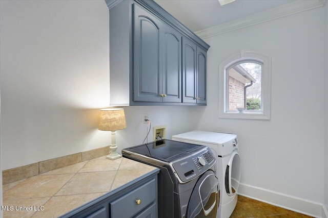 laundry room featuring cabinets, ornamental molding, and washer and dryer