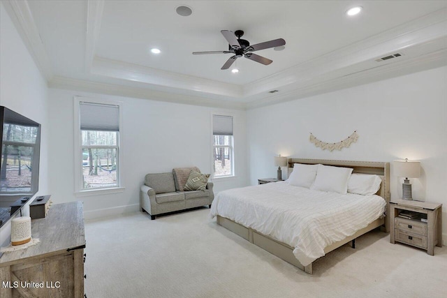 bedroom with a raised ceiling, crown molding, light colored carpet, and ceiling fan