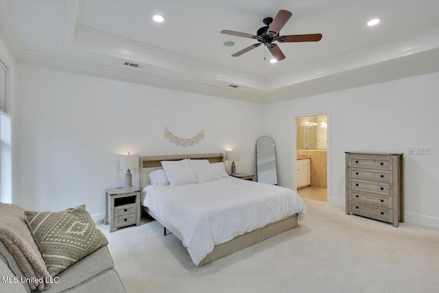 bedroom with crown molding, ceiling fan, ensuite bathroom, and a raised ceiling