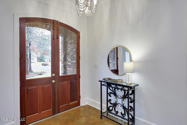 entrance foyer featuring tile patterned floors, an inviting chandelier, and french doors