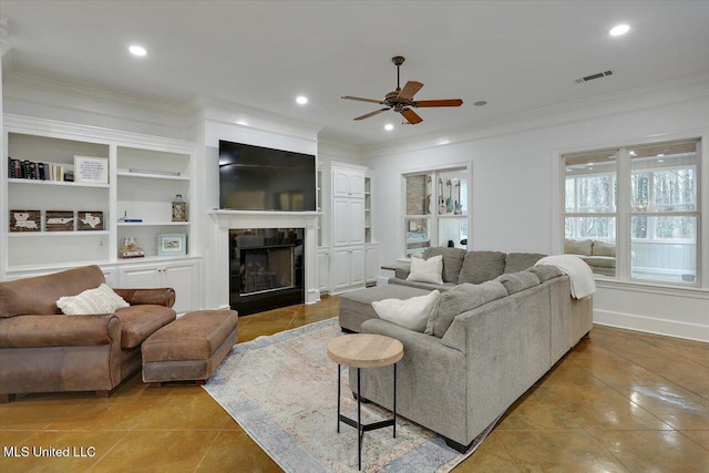 tiled living room with crown molding, ceiling fan, and built in features