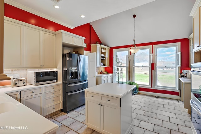 kitchen featuring tasteful backsplash, appliances with stainless steel finishes, light countertops, lofted ceiling, and hanging light fixtures