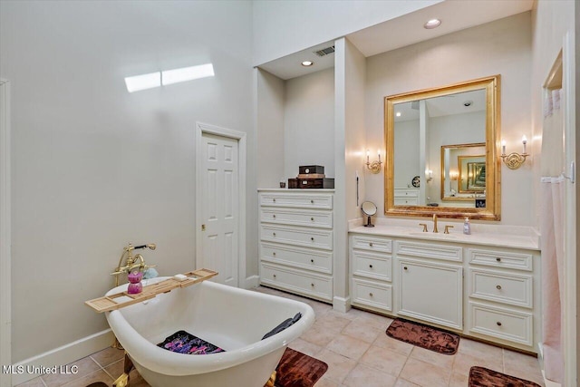 full bathroom featuring tile patterned floors, baseboards, a soaking tub, and vanity