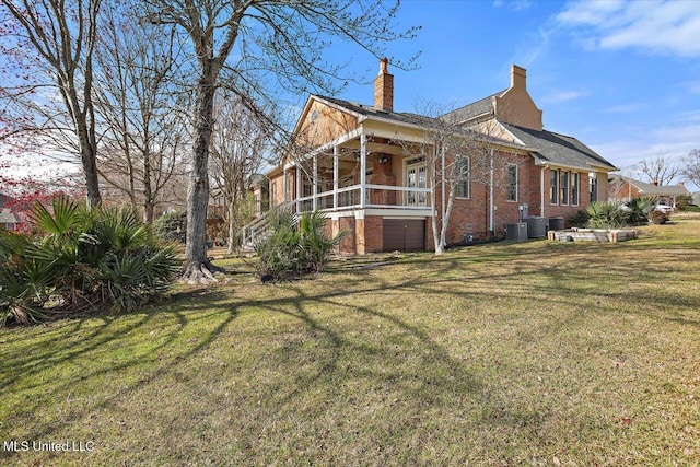 view of home's exterior featuring brick siding, covered porch, a lawn, and a chimney