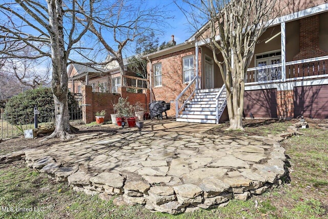 exterior space featuring brick siding and fence