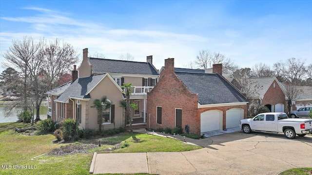 view of front of house featuring a front yard, a balcony, an attached garage, concrete driveway, and brick siding