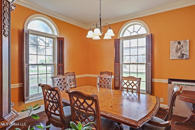 dining area featuring a healthy amount of sunlight, baseboards, an inviting chandelier, and ornamental molding