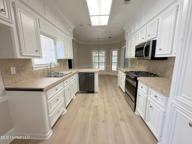 kitchen featuring a sink, light wood finished floors, white cabinetry, and stainless steel appliances