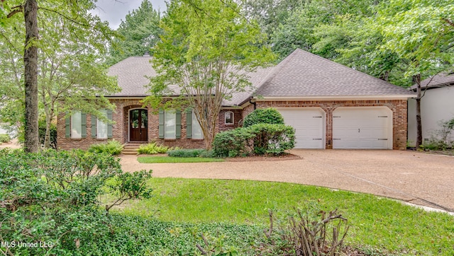 1025 Monet Cv, Brandon, MS 39047 - view of front of home featuring a shingled roof, a garage, brick siding, and driveway