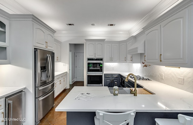 1025 Monet Cv, Brandon, MS 39047 - kitchen with appliances with stainless steel finishes, a peninsula, decorative backsplash, a sink, and ornamental molding