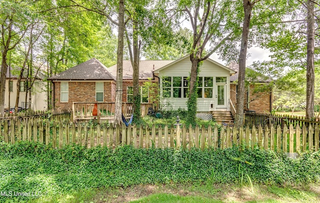 1025 Monet Cv, Brandon, MS 39047 - view of front of property featuring a fenced front yard, roof with shingles, a sunroom, and brick siding