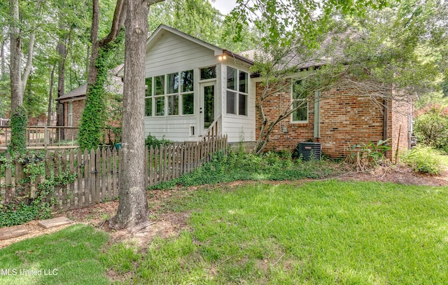 1025 Monet Cv, Brandon, MS 39047 - view of front facade with brick siding, a sunroom, and central AC unit