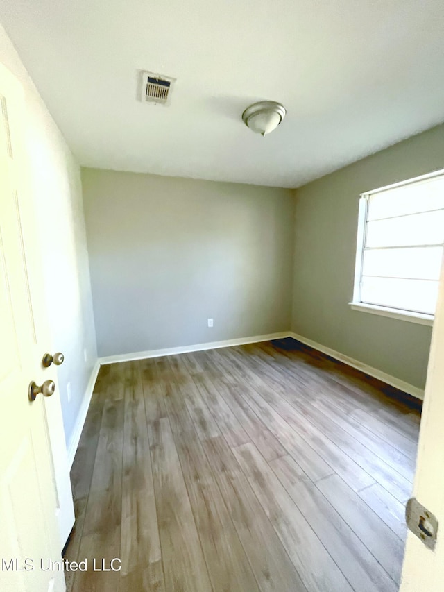 spare room featuring wood finished floors and baseboards