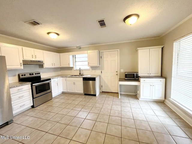 kitchen with stainless steel appliances, under cabinet range hood, crown molding, light tile patterned flooring, and white cabinetry