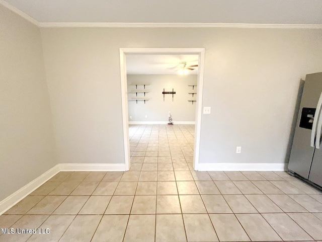 unfurnished room with crown molding, baseboards, and light tile patterned flooring