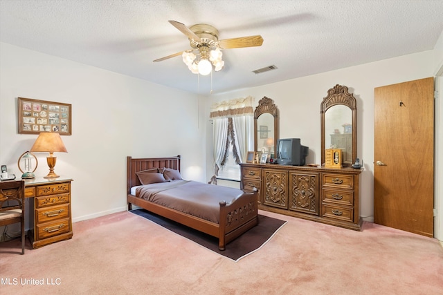 carpeted bedroom with a textured ceiling and ceiling fan