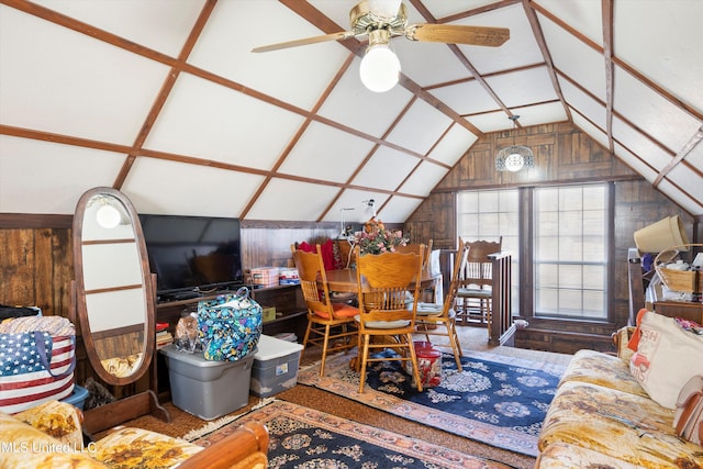 living room featuring wooden walls, vaulted ceiling, and ceiling fan