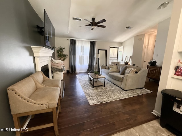 living area with ceiling fan, wood finished floors, a fireplace, and lofted ceiling