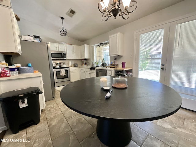 kitchen featuring stainless steel appliances, white cabinets, a chandelier, lofted ceiling, and light countertops