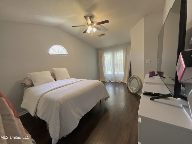 bedroom featuring dark wood-style flooring, vaulted ceiling, and ceiling fan