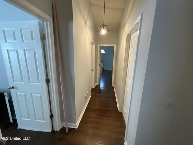 hallway with dark wood-style floors and baseboards