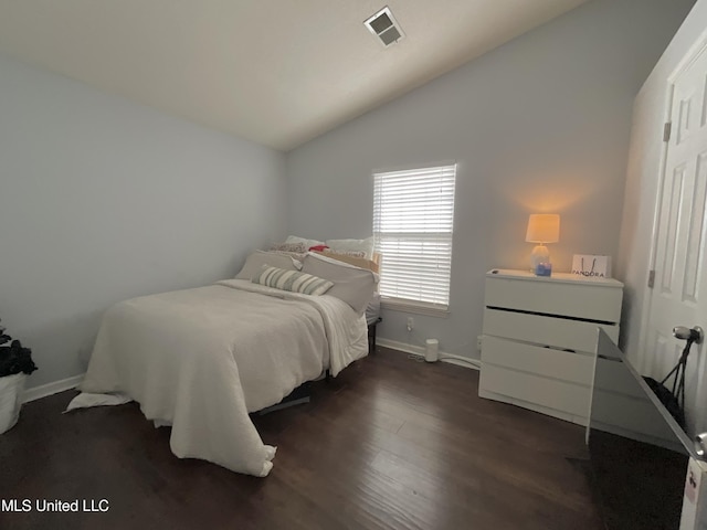 bedroom with vaulted ceiling, baseboards, and dark wood-style floors