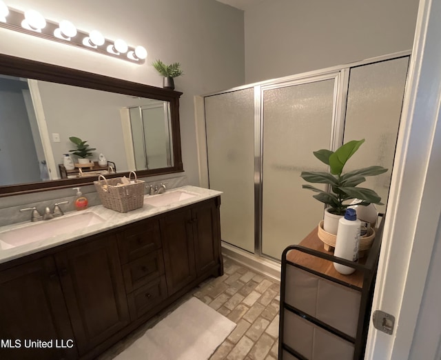 bathroom featuring brick patterned flooring, a shower stall, and double vanity