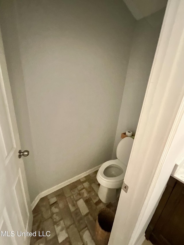 bathroom with toilet and baseboards