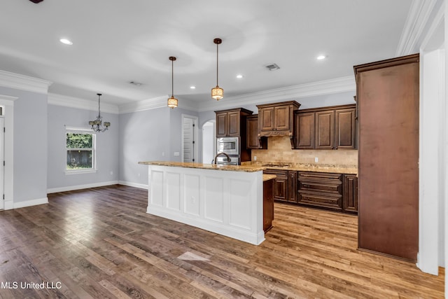 709 Champagne Dr, Biloxi, MS 39532 - kitchen featuring stainless steel appliances, wood finished floors, tasteful backsplash, a chandelier, and recessed lighting